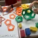 Mains d’enfants qui assemblent des formes en 3D avec des barrettes magnétiques, des sphères métalliques et des panels Geomag lors d’un atelier Mag4play à Lyon, dans le Rhône, en Rhône-Alpes et en Suisse romande.