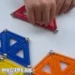 Main d’enfant qui positionne une barrette magnétique Geomag sur une structure avec sphères et panels colorés lors d’un atelier Mag4play à Lyon, dans le Rhône, en Rhône-Alpes et en Suisse romande.