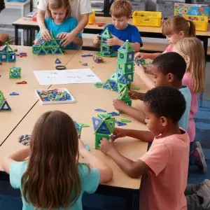 Groupe d'enfants concentrés participant à un atelier périscolaire Mag4Play dans une salle de classe à Lyon